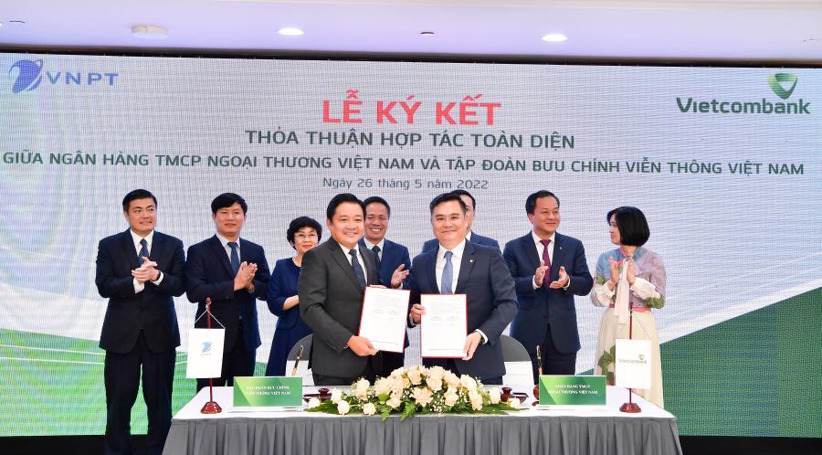 Ông Nguyễn Thanh Tùng - Phó Tổng Giám đốc Phụ trách BĐH Vietcombank (bên phải) và ông Huỳnh Quang Liêm - Tổng Giám đốc VNPT thực hiện nghi thức ký Thỏa thuận hợp tác toàn diện dưới sự chứng kiến của lãnh đạo 2 bên