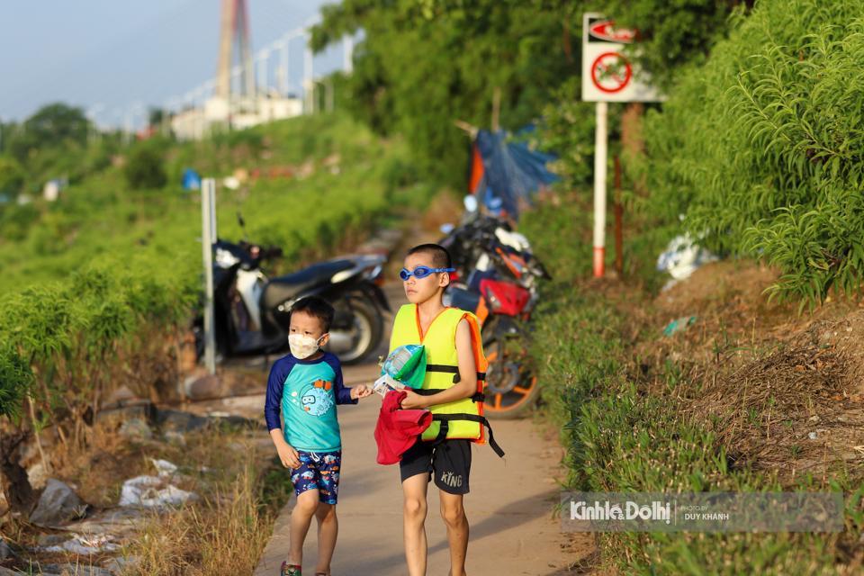 Tại khu vực bãi tắm tự phát ở phường Phú Thượng, quận Tây Hồ có khá đông người dân đến tắm, trong đó có khá nhiều trẻ em.