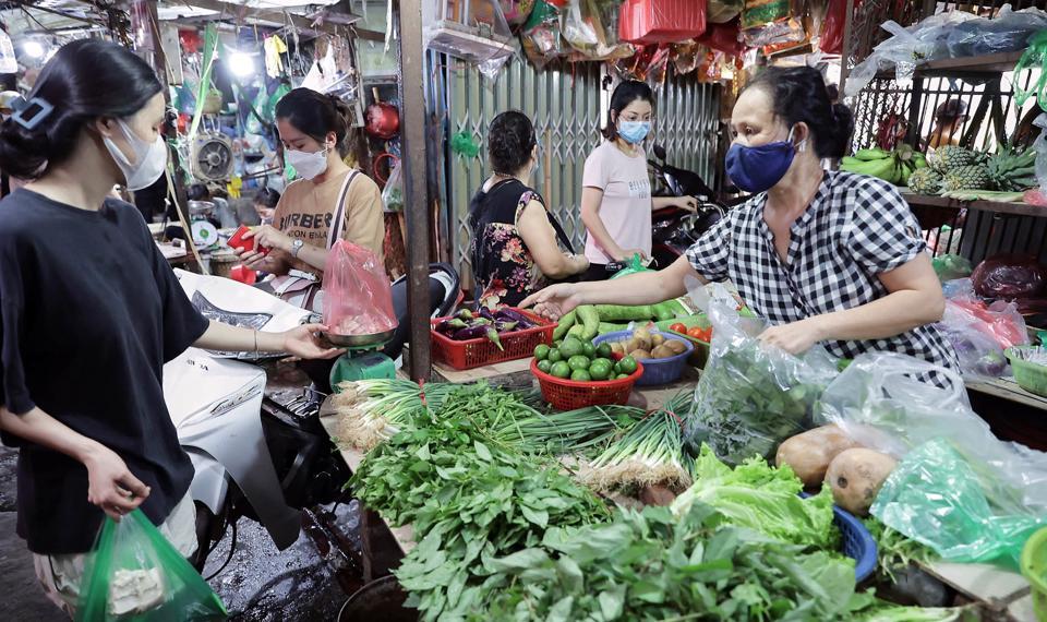 Người dân mua rau xanh tại chợ truyền thống