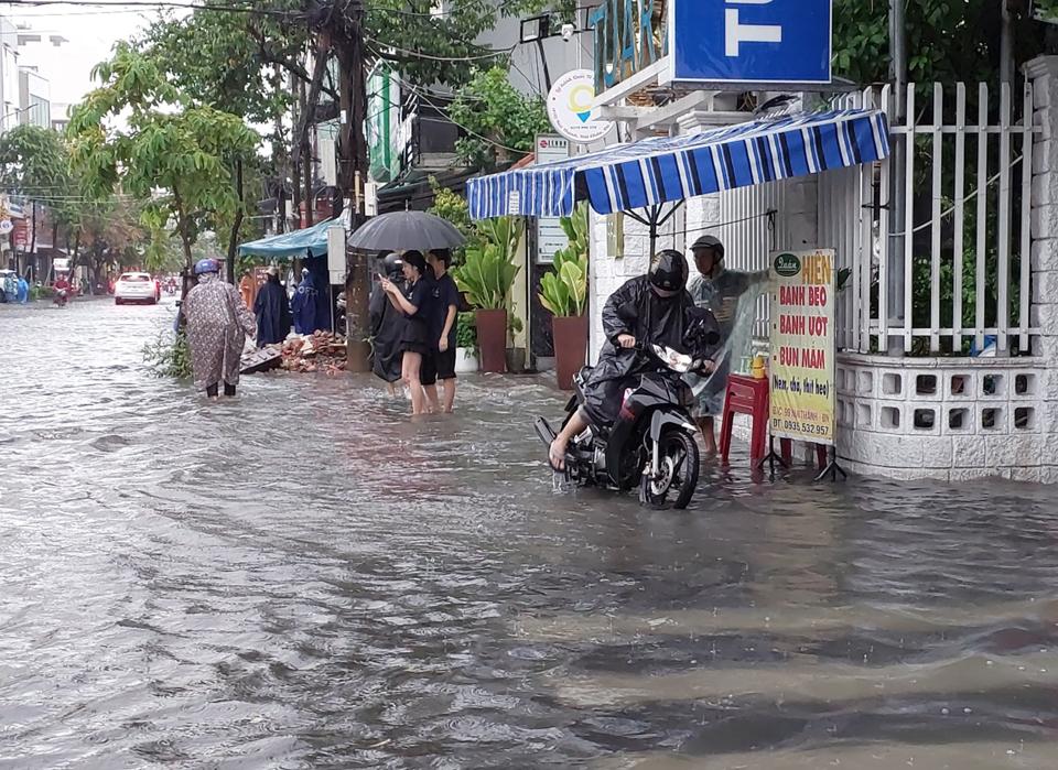 Nhiều người sử dụng xe máy đi làm sáng nay rất vất vả vì đường ngập. 