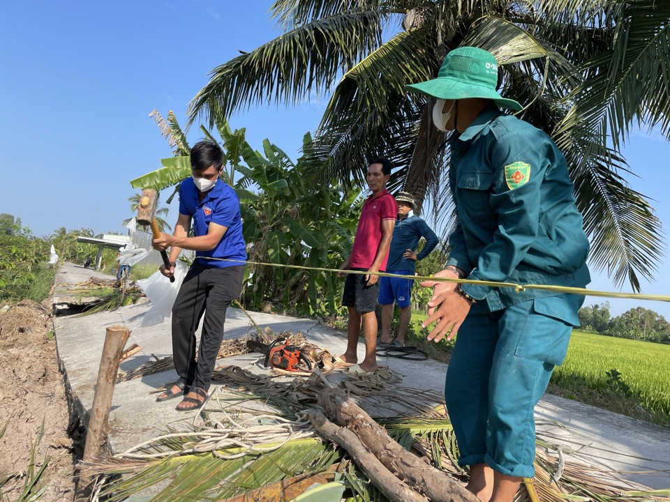 Một tuyến đường bị sụt lún không thể lưu thông, lực lượng dân quân của xã phải túc trực, giăng dây cảnh báo người dân (Hoàng Nam)