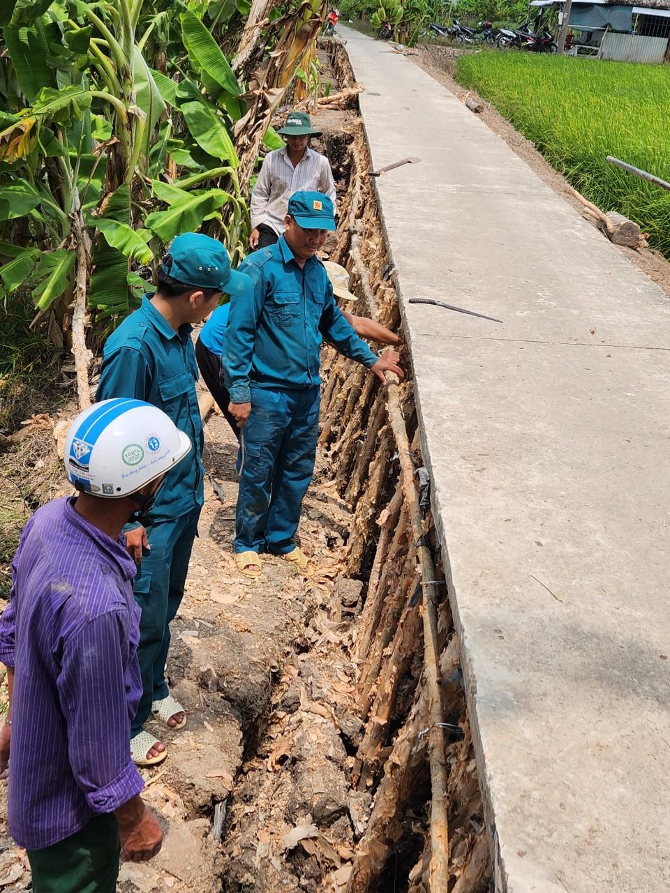 Lực lượng dân quân đang gia cố tuyến đường bị sụp lún ở xã Khánh Hải huyện Trần Văn Thời (Hoàng Nam).