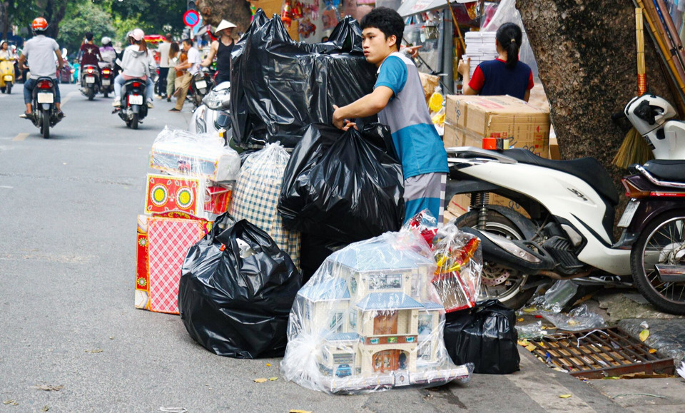 Người kinh doanh hàng mã trên phố Hàng Mã vận chuyển hàng tới người mua. Ảnh: Hoài Nam