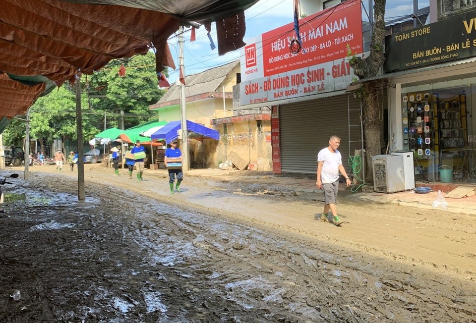 Khu vực chợ trung tâm huyện Trấn Yên (tỉnh Yên Bái) bị nước ngập lên đến gần 2m, rác bùn lên đến hơn 1m. “Ngày nào cũng phải có đến vài trăm người dọn dẹp, cào quét, kéo bùn ra. Làm liên tục 6 - 7 ngày, đường mới được như thế này, có nơi bùn vẫn ngập cao đến 20 - 30cm”, bà Nguyễn Thị Loan (ngụ đường Sông Thao, huyện Trấn Yên) chỉ con đường quanh chợ và nói. Bà guyễn Thị Loan kể thêm: “Cả đời tôi, chưa bao giờ thấy lũ lớn, ngập sâu như đợt này. Gần sông, ở phía trong có 2 nhà chỉ có cụ già hơn 70 tuổi và hơn 80 tuổi ở một mình, hôm nhà ngập cao lên tầng 2, ở trong không ra được, vẫy tay gọi mọi người đến cứu”.