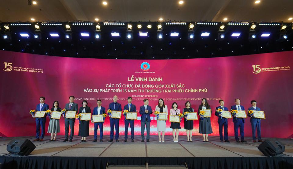 Đại diện Agribank, bà Võ Diệu Thúy (thứ 10 từ trái sang) - Giám đốc Trung tâm Kinh doanh Vốn và Tiền tệ Agribank, Phó Chủ tịch Hiệp hội thị trường trái phiếu Việt Nam (VBMA) nhận bằng khen của Bộ trưởng Bộ Tài chính cho Top 10 Nhà tạo lập thị trường trái phiếu Chính phủ Việt Nam.