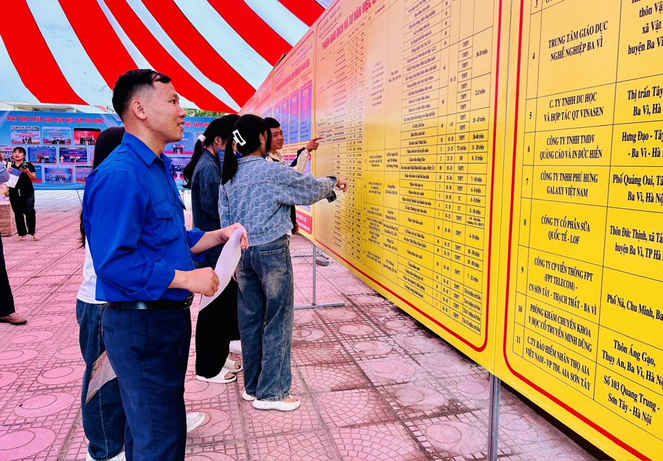 Người lao động xem thông tin tuyển dụng của các DN tại Phiên giao dịch và tư vấn iệc làm huyện Ba Vì năm 2024. Ảnh: Trần Oanh.