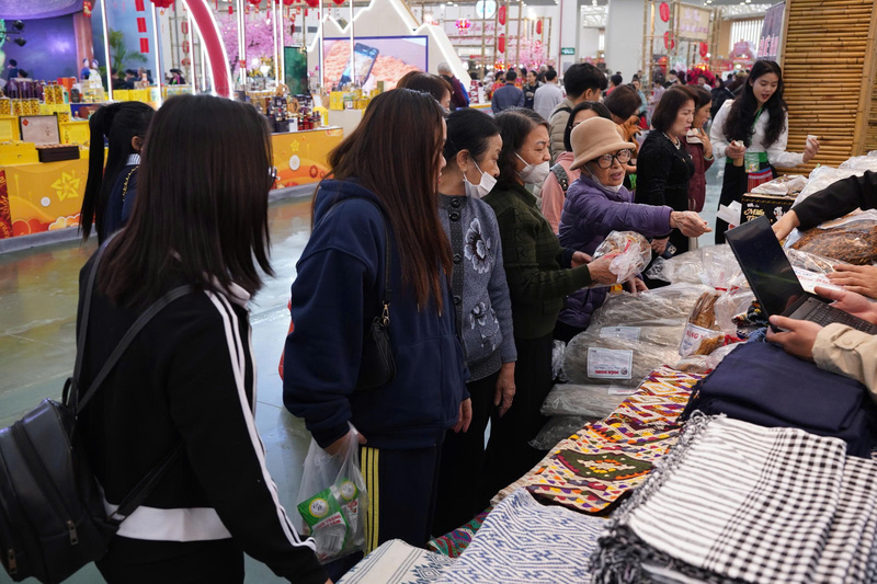 Đông đảo khách hàng tới gian hàng dệt thổ cẩm Pa Thơm để mua sắm các sản phẩm như khăn, váy, áo thổ cẩm. Ảnh: Mai Linh