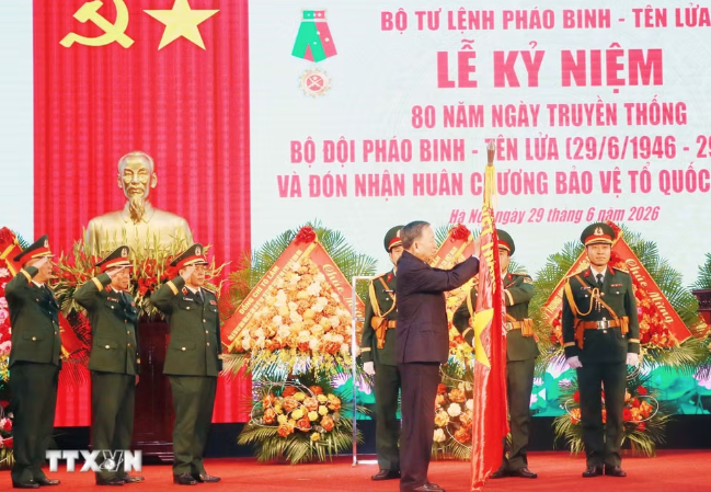 Tổng Bí thư, Chủ tịch nước Tô Lâm gắn Huân chương Bảo vệ Tổ quốc hạng Nhất lên Quân kỳ Quyết thắng của Bộ đội Pháo binh-Tên lửa. (Ảnh: Trọng Đức/TTXVN)